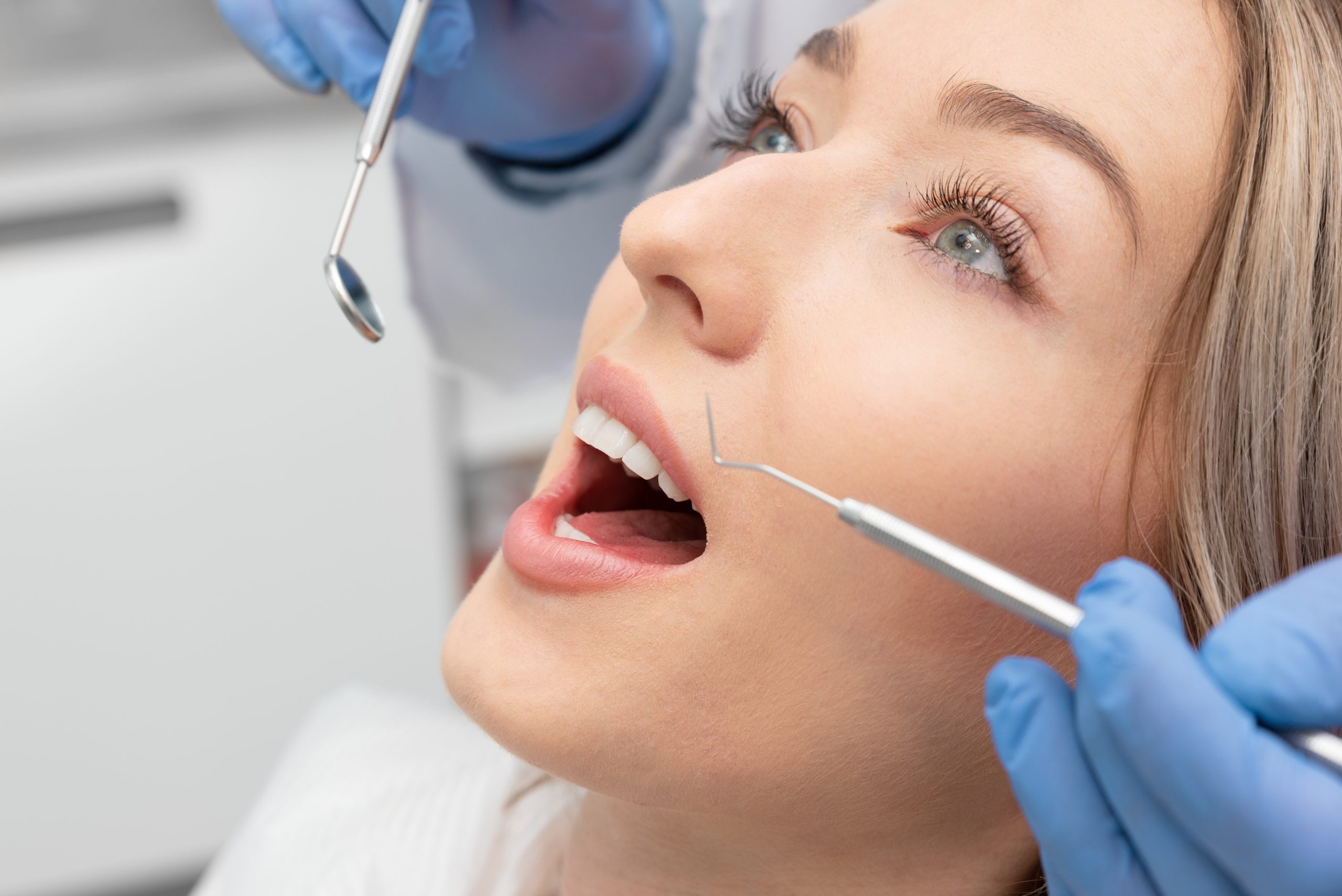 Woman having a dental checkup with a mirror and probe