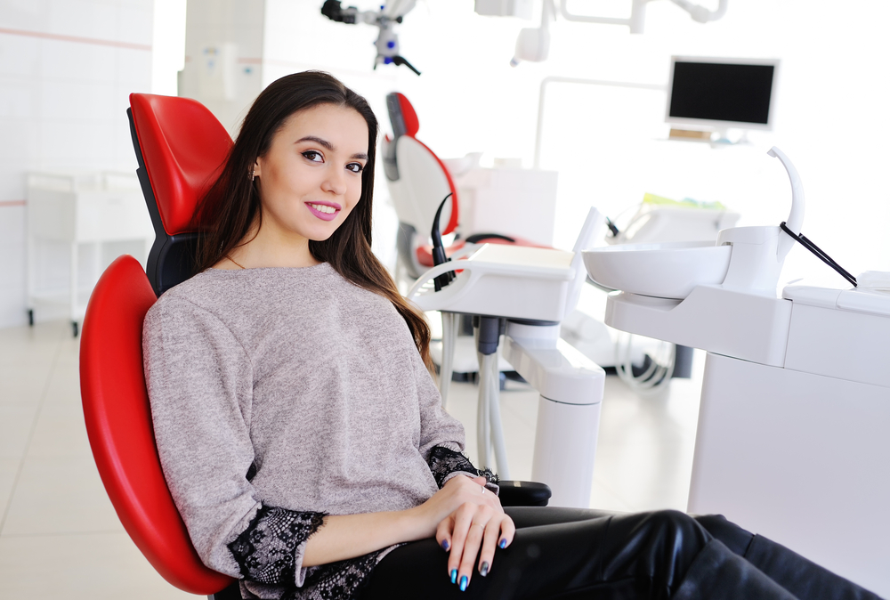 Woman having a dental checkup with a mirror and probe