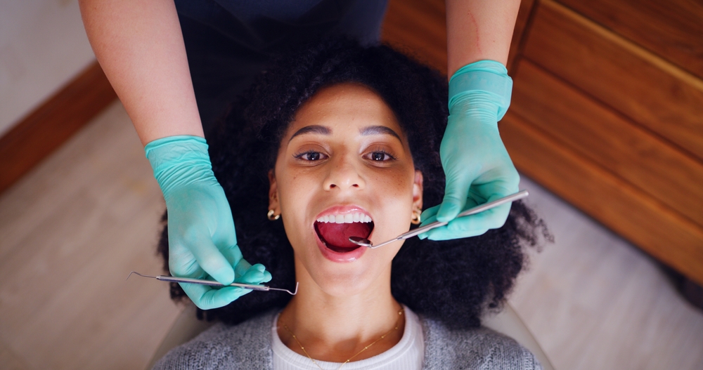 Woman having a dental checkup with a mirror and probe