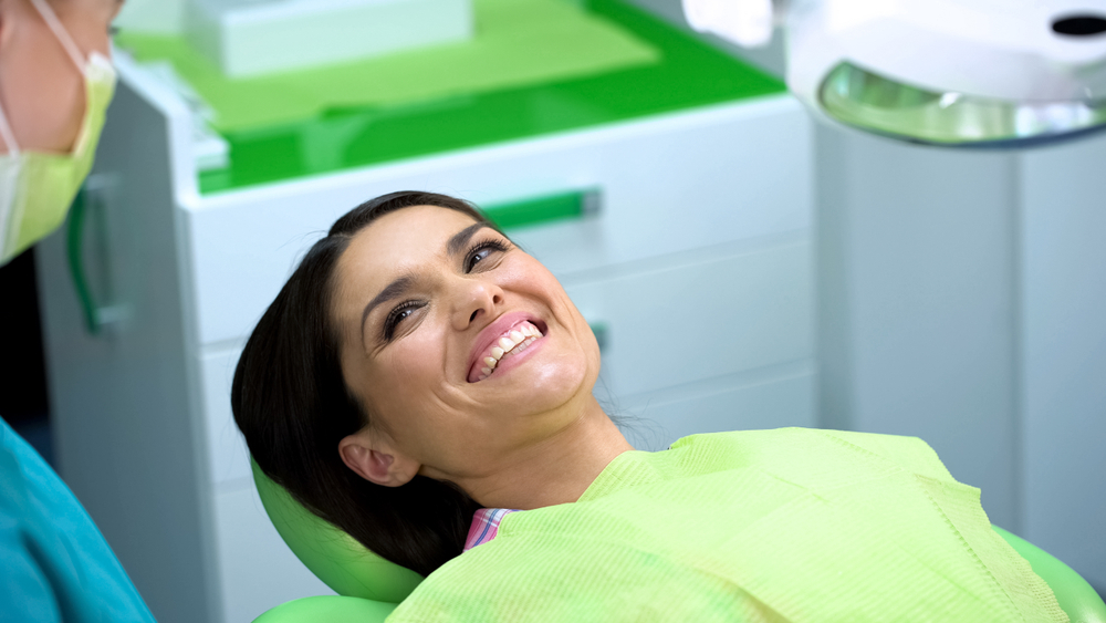 Woman having a dental checkup with a mirror and probe